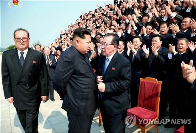 2015년 북한 대사회의에서 평양에 소집된 해외 파견 외교관들과 기념사진을 찍는 김정은 위원장. 김계관 당시 외무성 제1부상과 바짝 붙어 대화를 나누는 모습이다. [조선중앙TV 캡쳐=연합뉴스 자료사진] nkphoto@yna.co.kr