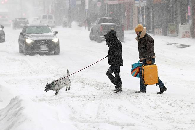 25일 겨울 폭풍이 지역을 휩쓸면서 뉴욕 브루클린에서 사람들이 눈길을 걷고 있다. /AFP 연합뉴스