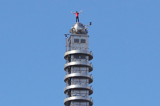 25일(현지시간) 알렉스 호놀드가 대만 타이베이의 초고층 빌딩 타이베이 101을 안전장비 없이 등반해 건물 꼭대기에 서 있다. 사진=AP 연합뉴스