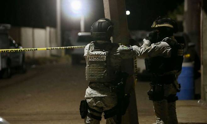 25일(현지시각) 멕시코 과나후아토주 살라망카에서 최소 11명이 숨지고 12명이 부상한 총격 사건 현장에서 국가방위군 대원들이 폴리스라인을 설치하고 있다. AFP 연합뉴스
