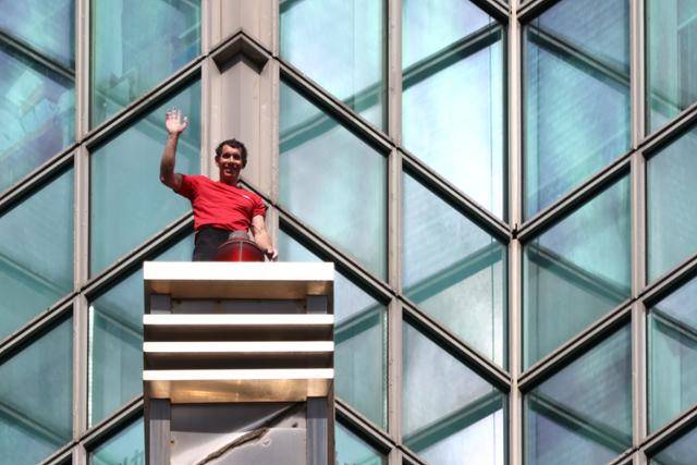 미국 암벽 등반가 알렉스 호놀드가 25일 대만 타이베이시 '타이베이 101' 빌딩을 오르던 중, 취재진과 관중을 향해 인사하고 있다. 타이베이=EPA 연합뉴스