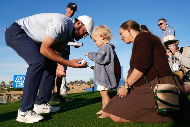 스코티 셰플러가 25일(현지 시간) 미국 캘리포니아주 라킨타의 ‘피트다이 스타디움코스’에서 열린 ‘아메리칸 익스프레스’에서 우승한 후 아들 베넷에게 골프공을 건네고 있다. AP연합뉴스
