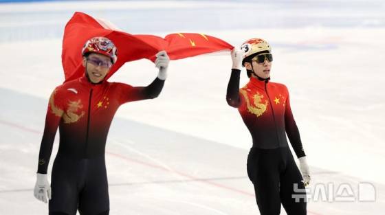 중국 하얼빈 헤이룽장 빙상훈련센터에서 열린 2025 하얼빈 동계 아시안게임 쇼트트랙 남자 500m 결승 경기에서 중국 린샤오쥔(오른쪽)이 금메달을 확정지은 뒤 4위 쑨룽과 함께 오성홍기를 들고 기뻐하고 있다. /사진=뉴시스