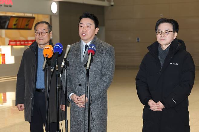 강훈식(가운데) 대통령실 비서실장이 26일 인천국제공항에서 출국 직전 취재진과 만나 '캐나다 초계 잠수함 프로젝트(CPSP)' 등 방산 협력에 관한 질문에 답하고 있다. 왼쪽은 이용철 방위사업청장, 오른쪽은 김정관 산업통상부 장관이다. /뉴시스