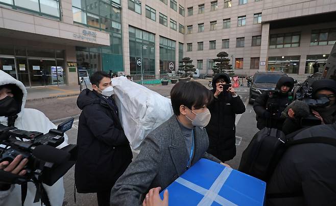 북한의 한국 무인기 침투 주장에 대한 진상을 규명하는 ‘군경합동조사 TF’가 21일 민간인 피의자 3명의 주거지 및 사무실 등에 대한 압수수색에 나선 가운데 이날 피의자 장모씨와 오모씨가 다니던 서울의 한 대학교 공대 건물에서 경찰 관계자들이 압수품을 옮기고 있다. 연합뉴스