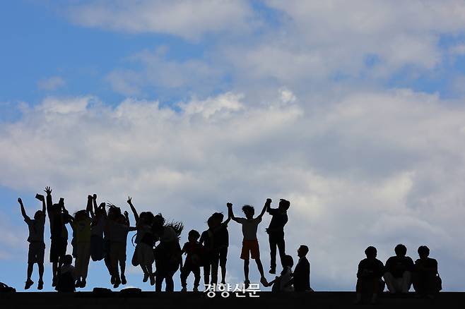 서울 용산구 국립중앙박물관에 소풍 온 학생들이 파란 하늘과 흰 구름을 배경 삼아 즐겁게 뛰고 있다. 경향신문 자료사진