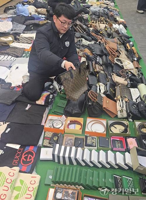 인천세관 관계자가 압수한 중국산 ‘짝퉁’ 위조 상품을 들어보이고 있다. 조병석기자