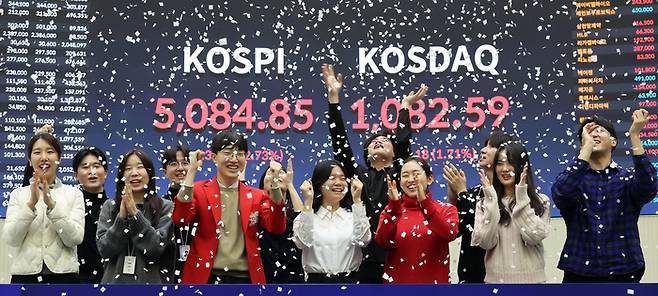 27일 코스피지수가 종가기준 사상처음 5000포인트를 갱신간 가운데 여의도 한국거래소 홍보관에서 직원들이 축하 세레머니를 하고 있다. [이승환 기자]