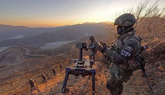5사단 열쇠부대 군 장병들이 지난 경기 연천군 접경지역에서 시범 운용 중인 다족 보행 로봇과 함께 철책 경계 근무를 하는 모습. 연합뉴스