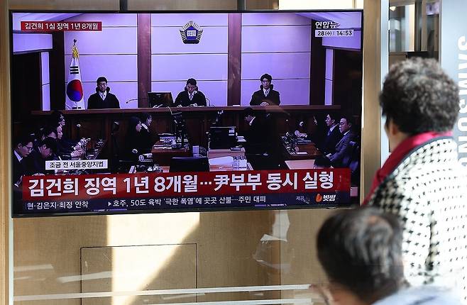 김건희 씨의 자본시장법·정치자금법 위반, 특정범죄 가중처벌법상 알선수재 혐의 사건의 선고 공판이 열린 28일 서울 용산구 서울역 대합실에서 시민들이 관련 뉴스를 지켜보고 있다. 연합뉴스