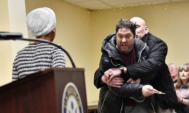 27일 미국 미네소타주 미니애폴리스에서 열린 타운홀 미팅에서 한 남성이 일한 오마르 하원의원(미네소타주·민주당)을 향해 정체불명의 물질을 뿌렸다. AFP연합뉴스