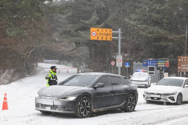 폭설이 쏟아진 11일 오전 제주시 어승생 삼거리 1100도로 입구에서 경찰이 차량 진입을 통제하고 있다.