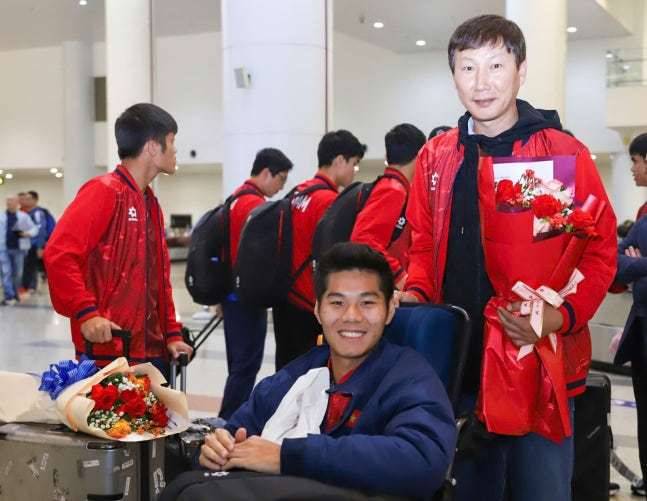 부상당한 선수의 휠체어를 밀어 주는 김상식(오른쪽) 감독. /사진=베트남넷 갈무리