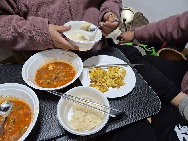 28일 서울 종로구 돈의동 쪽방촌에 거주하는 송종택씨 부부가 김치찌개와 계란 부침으로 끼니를 해결하고 있다. 방안으로 냉기가 스며들어 식사를 하는 동안에도 외투를 벗기 어렵다. 오지은 기자