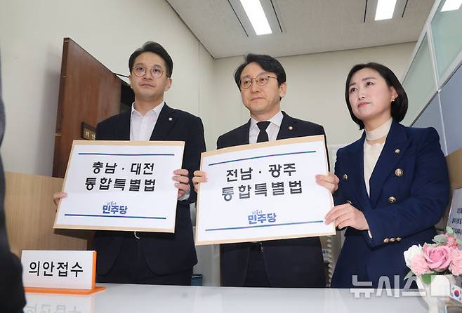 [서울=뉴시스] 조성봉 기자 = 전용기(왼쪽부터) 원내소통수석부대표, 천준호 원내운영수석부대표, 백승아 원내대변인이 30일 서울 여의도 국회 의안과에서 '충남대전통합특별법안 · 전남광주통합특별법안'을 제출하고 있다. (공동취재) 2026.01.30. photo@newsis.com