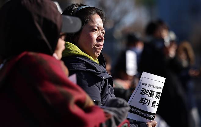 장애인 활동가 문애린(왼쪽 둘째)씨가 2026년 1월29일 오전 서울 서초구 서울중앙지방법원에서 열린 ‘장애인 권리 확보를 위한 투쟁에 대한 무죄판결 촉구 및 장애인 이동권 침해 및 공권력 남용에 대한 차별구제 청구소송 기자회견’에서 입술을 굳게 다물고 있다.