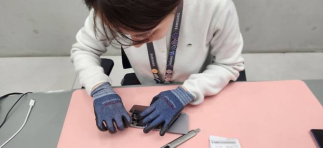 갤럭시 Z 플립 6를 분해하고 있는 최수정 엔지니어. 백재연 기자