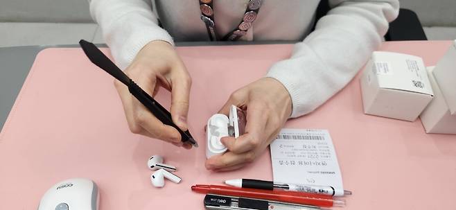 최씨가 헤라를 이용해 갤럭시 버즈3 프로를 분해하고 있다. 백재연 기자