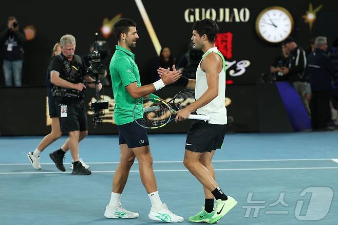 노박 조코비치(세르비아)가 1일 호주 멜버른에서 열린 호주오픈 테니스 대회 남자 단식 결승에서 우승을 차지한 카를로스 알카라스(스페인)에게 축하를 건네고 있다.  ⓒ AFP=뉴스1