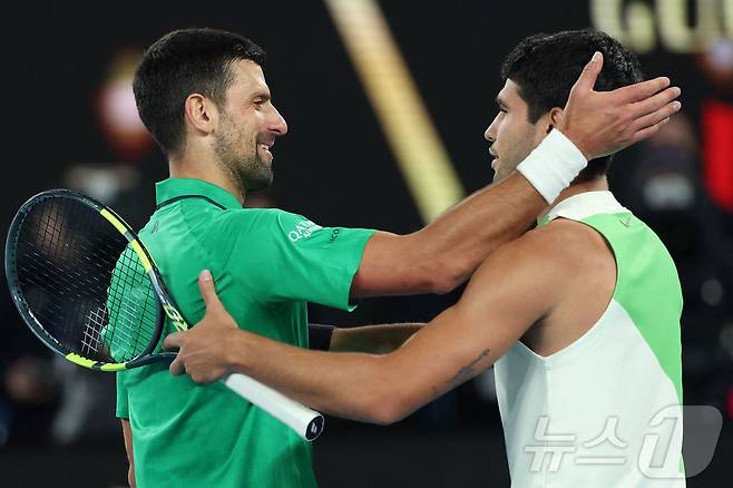 카를로스 알카라스(스페인)가 1일 호주 멜버른에서 열린 호주오픈 테니스 대회 남자 단식 결승에서 노박 조코비치(세르비아)를 꺾고 우승을 차지, 조코비치의 축하를 받고 있다. ⓒ AFP=뉴스1