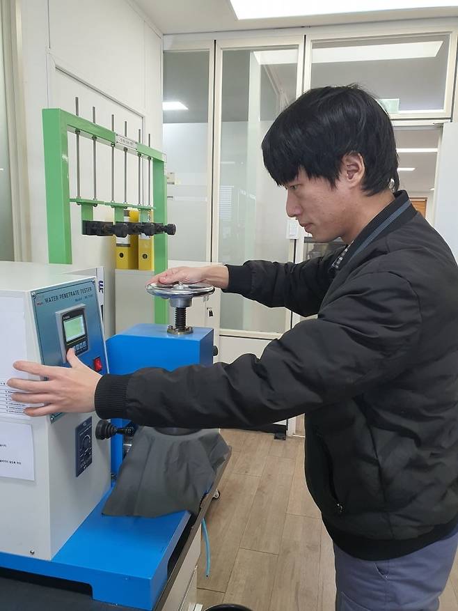 박지훈 차장이 우의 방수 기능을 점검하고 있다. 안산=윤현주 기자