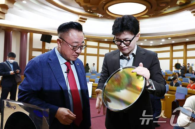 2024년 10월 29일 당시 국민의힘 한동훈 대표가 서울 여의도 국회 의원회관에서 '왜 AI와 반도체를 함께 이야기 하는가?'를 주제로 열린 국민의힘 초선의원 공부모임에서 고동진 의원과 함께 반도체 웨이퍼를 살펴보고 있다. 2024.10.29/뉴스1 ⓒ News1 김민지 기자