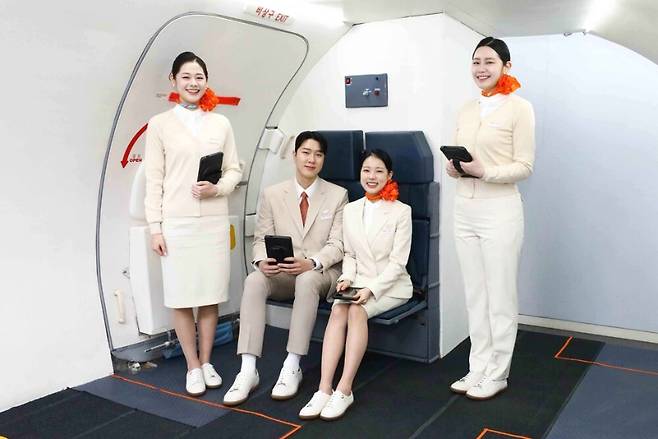 제주항공 객실승무원들이 기내 비상구 인근에서 스니커즈 근무화를 착용한 모습. 장시간 근무 부담을 줄이고 비상상황 대응력을 높이기 위한 현장 중심의 변화가 시작됐다. (제주항공 제공)