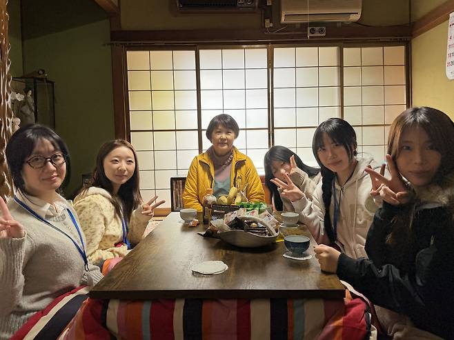 Five Korean undergraduates sit around a kotatsu, a Japanese heated table, with their home-stay host, center, at a house in Tokushima Prefecture in Japan on Jan. 25. [LEE SOO-JUNG]