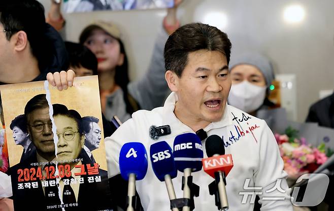 전한길 전 한국사 강사가 3일 인천국제공항 제2여객터미널로 귀국해 기자회견에서 자신이 제작한 영화 포스터를 들어보이고 있다. 2026.2.3/뉴스1 ⓒ News1 이호윤 기자