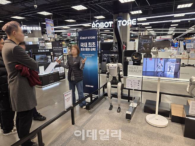 영등포점 일렉트로마트에 마련된 로봇 판매 매장에서 고객들이 휴머노이드 로봇을 살펴보고 있다. (사진=한전진 기자)