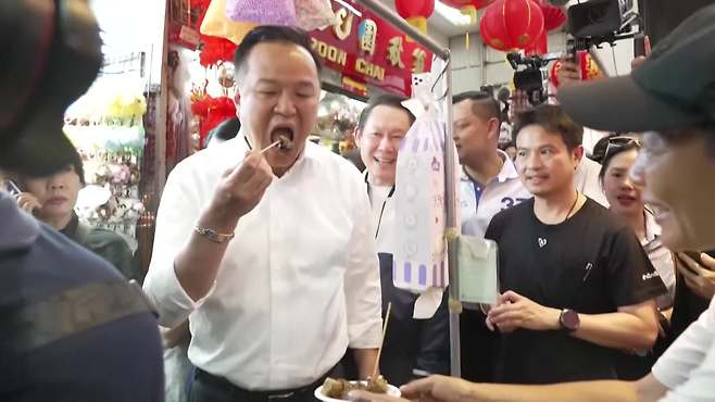 품짜이타이당의 총리 후보로 나선 아누틴 현 총리. 시장 유세 도중 음식을 먹고 있다.(사진 출처 : 로이터)