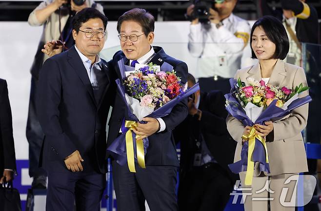 이재명 더불어민주당 대통령 당시 대통령 후보가 김혜경 여사와 지난해 6월 4일 오전 서울 여의도 국회 앞을 찾아 당시 박찬대 상임총괄선대본부장으로부터 꽃다발을 받고 있다. (공동취재) 2025.6.4/뉴스1 ⓒ News1 안은나 기자