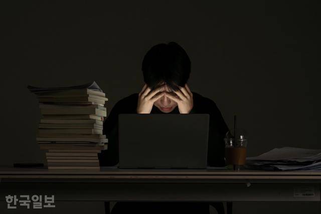 야근하는 직장인이 노트북을 편 채 이마를 부여잡고 있다. 연출해 촬영한 사진. 박시몬 기자