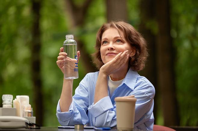 중년 여성이 생수를 손에 든 채 즐거운 추억을 떠올리고 있다. 당뇨병 환자는 설탕이 듬뿍 들어간 코카콜라 같은 음료를 피해야 한다. 이런 음료는 혈당 스파이크를 일으켜 혈당 조절을 방해하고 합병증 위험을 높인다. 설탕 대신 인공 감미료가 들어간 제로 음료를 마시는 것이 차선책이 될 수 있으나, 최선의 방법은 맹물이나 생수를 마시는 것이다. 사진=게티이미지뱅크