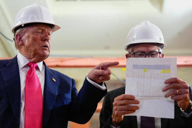 도널드 트럼프(왼쪽) 미국 대통령과 제롬 파월 미 연방준비제도(Fed·연준) 의장이 지난해 7월 개·보수 공사 중인 워싱턴 연준 건물에서 청사 공사비를 두고 언쟁을 벌이고 있다. 워싱턴=로이터 연합뉴스