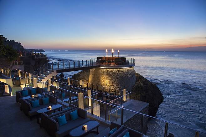 짐바란 해변의 석양 속 아야나 리조트 시그니처 락 바 전경. 사진제공|팜투어