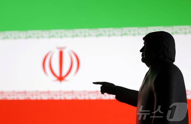 도널드 트럼프 미국 대통령의 뒤로 이란 국기가 펼쳐진 모습. 2025.06.18 ⓒ 로이터=뉴스1