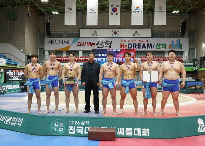 강원특별자치도 삼척시 삼척체육관에서 열린 '2026 삼척 전국대학장사씨름대회' 대학부 단체전 우승을 차지한 동아대학교(부산광역시)가 김원하 삼척시씨름협회장(왼쪽에서 네 번째) 기념사진을 찍고 있다. /사진=대한씨름협회 제공