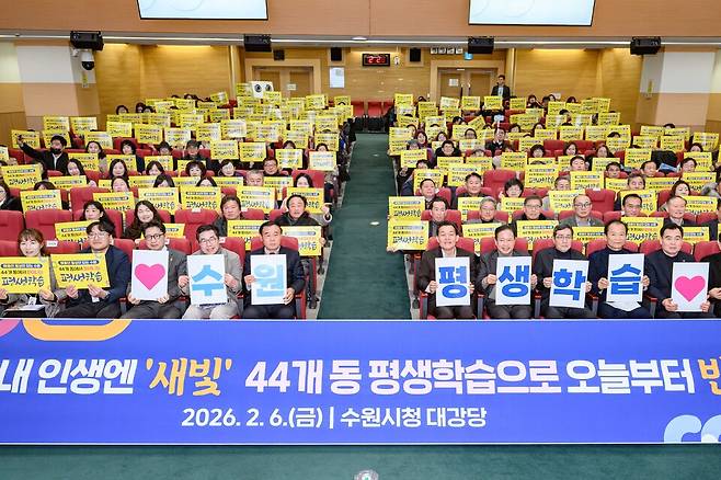 지난 6일 수원시청 대강당에서 44개동 평생학습센터 설명회에서 이재준 수원시장 등 참석자들이 피켓을 듣고 기념사진을 찍고 있다.<수원시 제공>