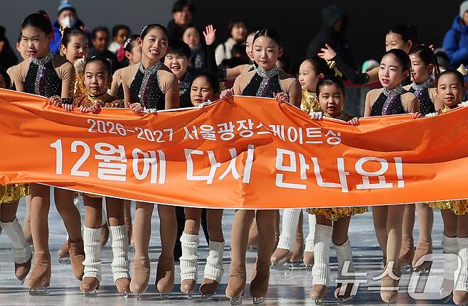 겨울철 서울 도심 대표 명소로 자리매김한 서울광장 스케이트장이 폐장한 8일 오후 스케이트장 메인링크에서 리라피겨그룹 선수들이 피날레 공연을 마친 후 현수막을 들고 인사하고 있다. 2026.2.8 ⓒ 뉴스1 오대일 기자