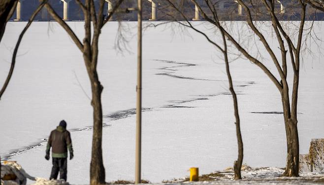 한 시민이 한강 물이 얼어붙은 서울 강동구 광진교 주변을 산책하고 있다.