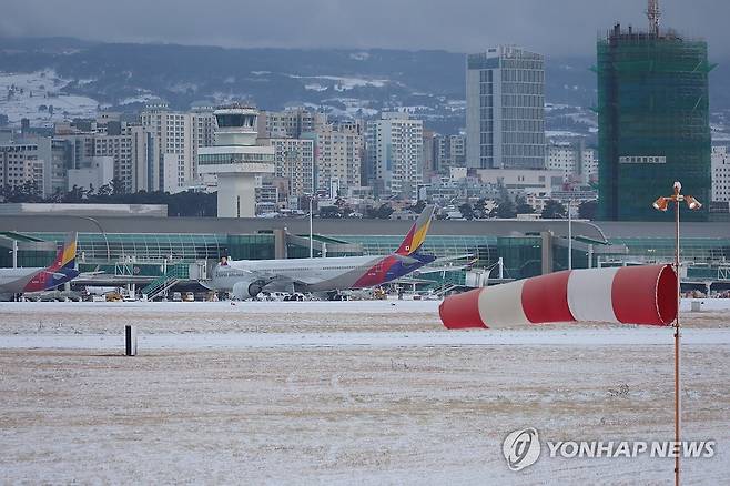 멈춰 선 제주공항 (제주=연합뉴스) 고성식 기자 = 8일 제주국제공항에 많은 눈이 내려 제설작업으로 공항 운영이 오전 한때 중단된 가운데 제주공항 활주로에 강한 바람이 불고 눈이 쌓여 있다. 2026.2.8 koss@yna.co.kr