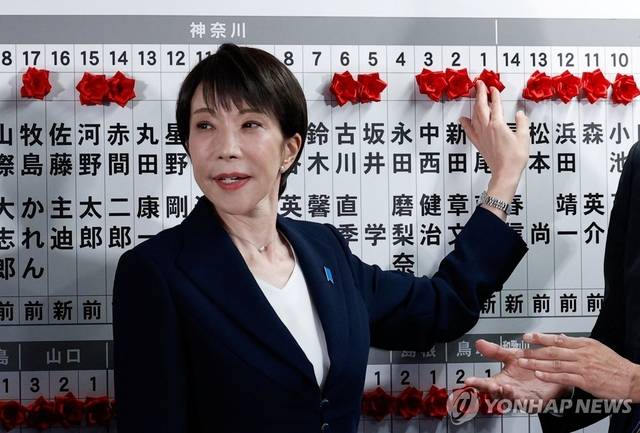 다카이치 사나에 일본 총리가 8일 중의원 선거(총선)에서 승리한 집권 자민당 후보 이름 위에 꽃을 붙이고 있다. 로이터 연합뉴스