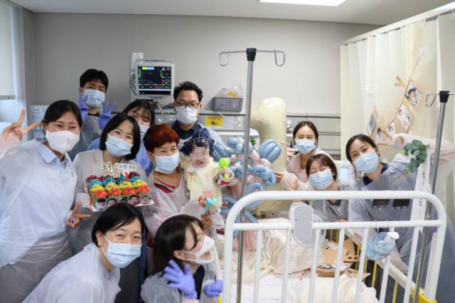 지난해 6월 하늘이의 첫돌을 맞아 소아중환자실 의료진들이 함께 기념사진을 촬영했다. 속초에서 온 하늘이의 엄마 김미소(가명)씨의 후견인 한순희 씨와 장애인 지원 봉사자 홍현표 씨도 돌잔치를 함께했다. 홍현표씨 제공