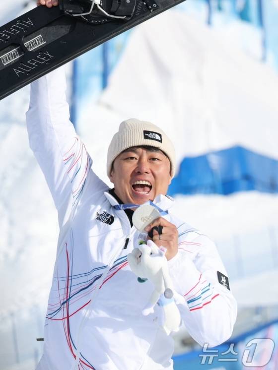 김상겸이 지난 8일(한국시간) 이탈리아 리비뇨 스노파크에서 열린 2026 밀라노·코르티나담페초 동계올림픽 남자 평행대회전 시상대에 서서 왼손에는 은메달을, 오른손에는 스노보드를 잡고 있다. /사진=뉴스1