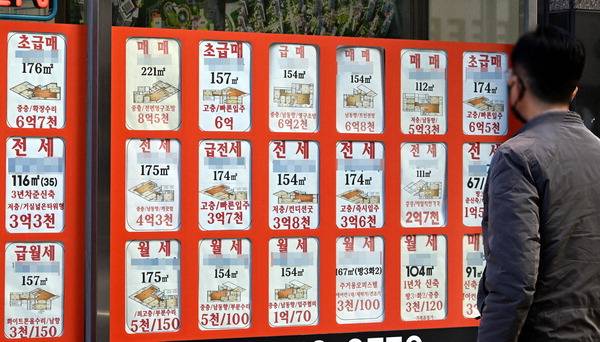 부산 동래구의 한 공인중개사 사무소 유리벽에 빼곡히 붙은 매물 정보를 시민이 살펴보고 있다.  국제신문DB