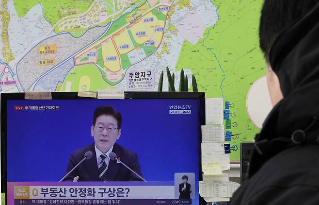 An employee at a real estate brokerage office in Seocho District, southern Seoul, watches President Lee Jae Myung’s remarks on housing during his New Year press conference on Jan. 21. [YONHAP]