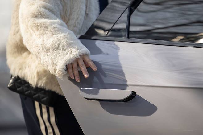 A passenger opens a car door with a concealed car door handle in Beijing on Feb. 3. [EPA/YONHAP]