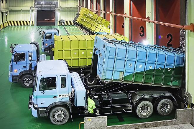 Garbage trucks unload waste at the bunkers of the Mapo Resource Recovery Plant in western Seoul, in an undated video shown at the facility. [PARK SANG-MOON]