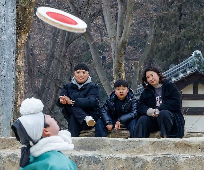 설 연휴를 앞둔 10일 경기 용인시 한국민속촌에서 한 가족이 민속공연 ‘삼도판굿’을 지켜보며 즐거운 시간을 보내고 있다.&nbsp;